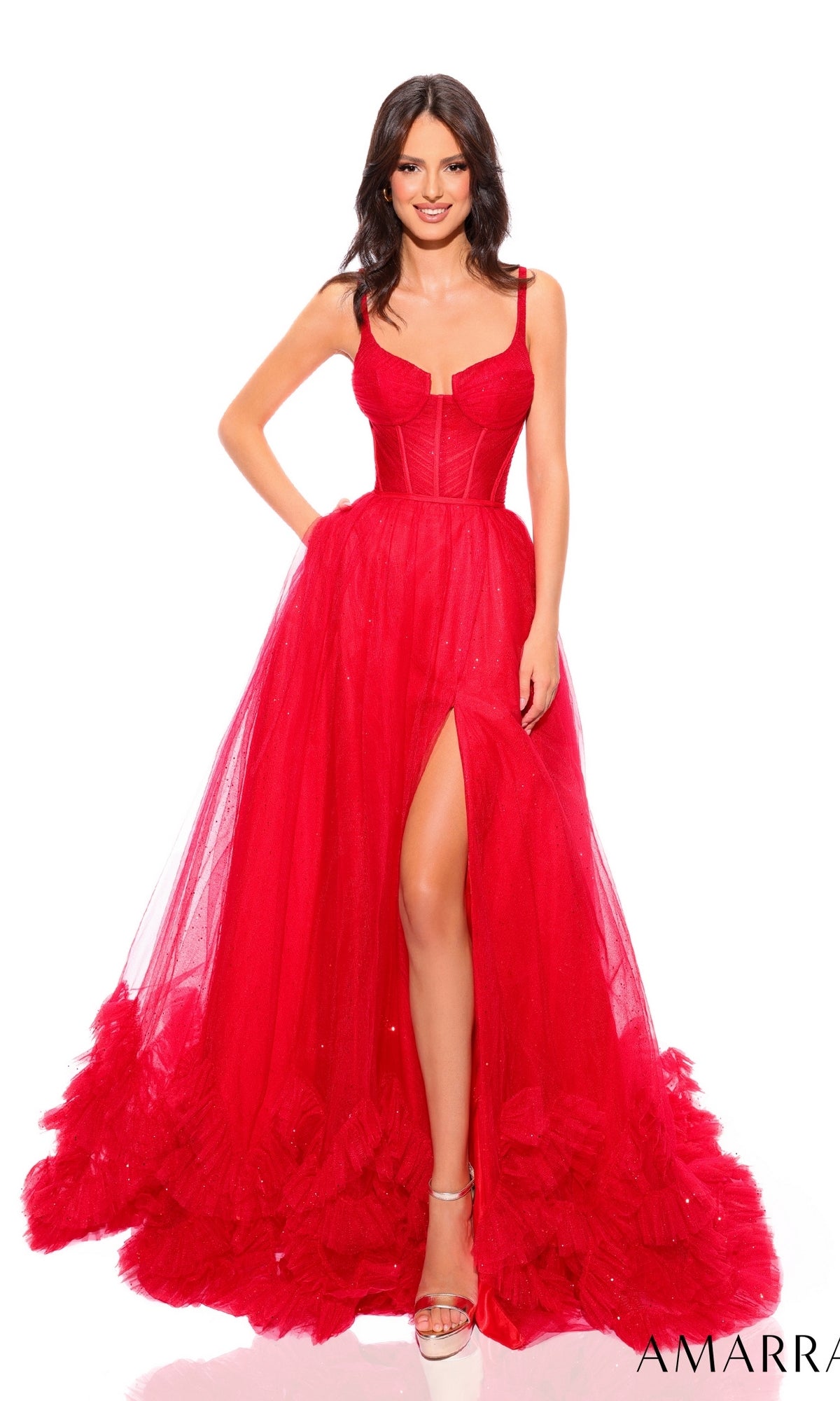A woman stands against a white background wearing the Sheer-Corset Long A-Line Ruffled Prom Dress 88872, a bright red strapless gown with a full tulle skirt, high slit, corset waist, and feathered hem.